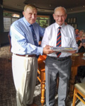 Derek Wood presents Harry Archer with a copy of "Roger So Far", the Corps Centenary book